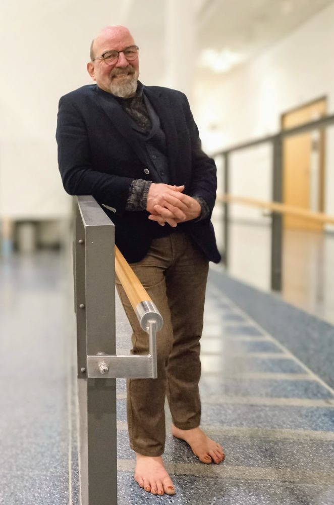 Thomas Nawroth lehnt an einem Geländer in einem Geschäftsgebäude