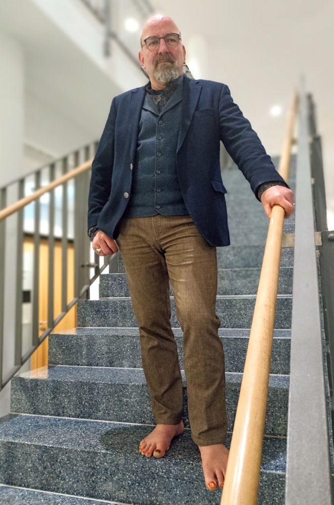 Thomas Nawroth steht nachdenklich auf einer Treppe in einem Geschäftshaus