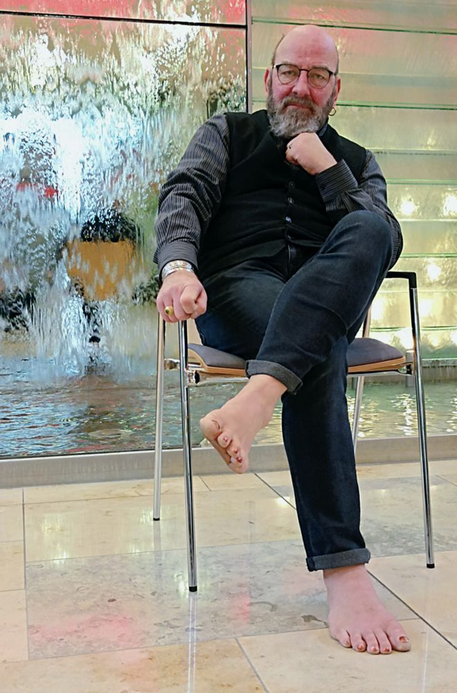Thomas Nawroth sitzt in einer Halle mit einer Wasserinstallation