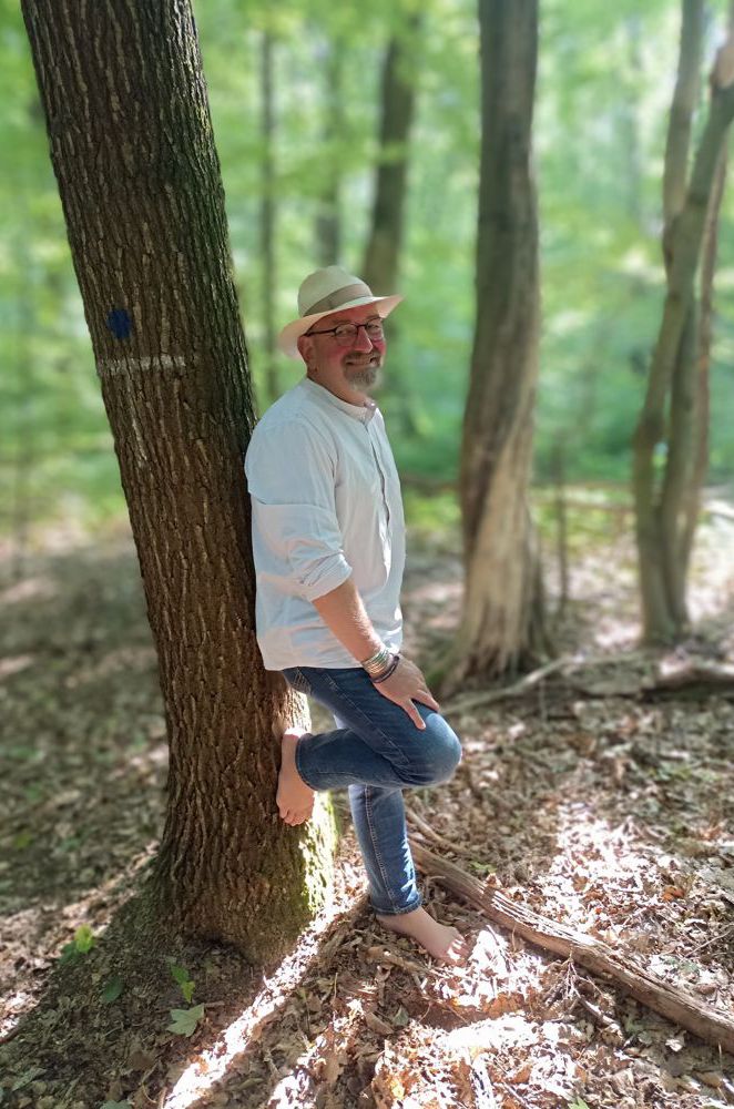 Thomas Nawroth lehnt entspannt an einem Baum