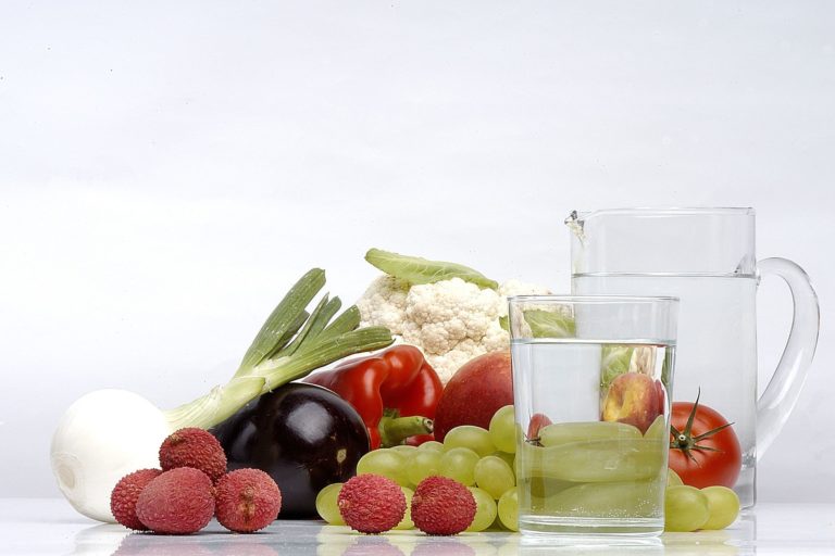 Stillleben aus Obst und Gemüse sowie einem Glas und einem Krug mit Wasser